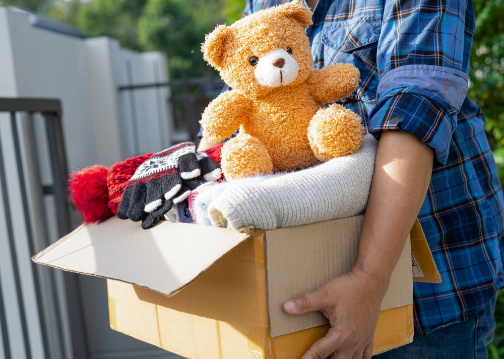 box filled with unhelpful disaster donations including clothes and a teddy bear